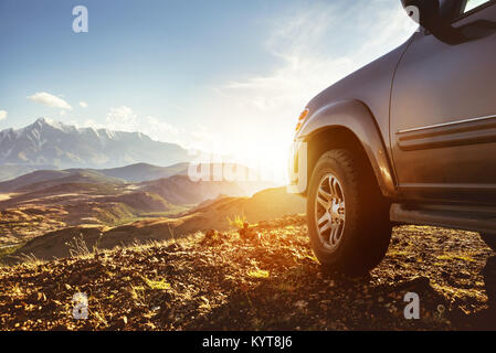 Big 4x4 car against sunset and mountains Stock Photo