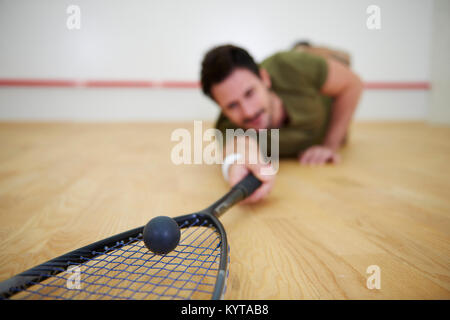 Male player falling on floor while squash game Stock Photo