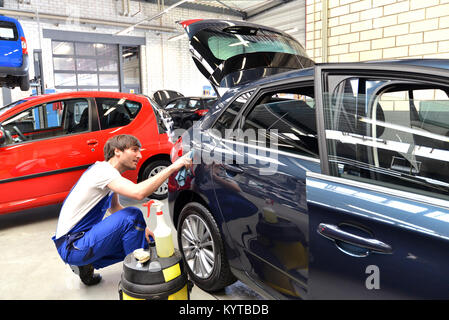 man in a workshop cleaning a car - service for the customer Stock Photo