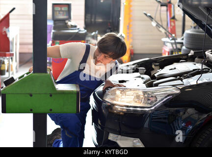 mechanic adjusts headlights from the car in a workshop Stock Photo