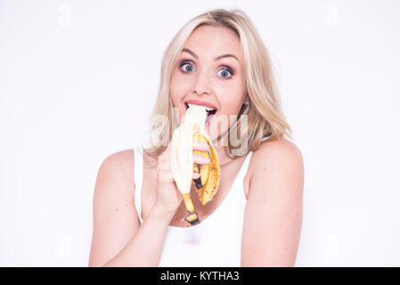 Pretty blonde woman eating a banana Stock Photo