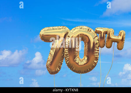 Gold number 70 foil birthday balloon against a bright blue summer sky. Golden party celebration. 3D Rendering Stock Photo