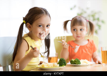 Children eating healthy food in kindergarten, nursery or at home Stock Photo