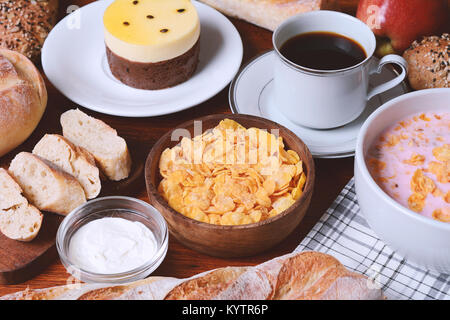 Close up of passion fruit cake, toast, coffee, yogurt, cereals. Continental breakfast Stock Photo