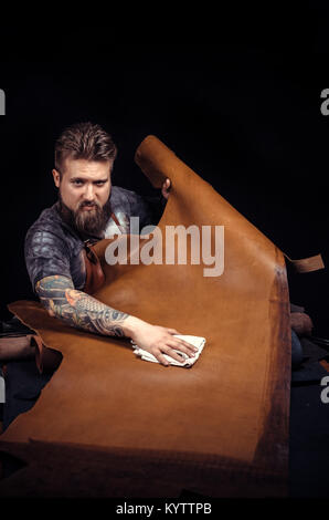 Artisan working with leather working with leather in his studio Stock Photo