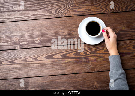 Overhead shot of woman's hands holding cup of coffee Stock Photo