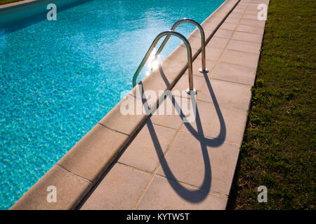 Graphic semi-abstract shape of outdoor swimming pool ladder shadows Stock Photo
