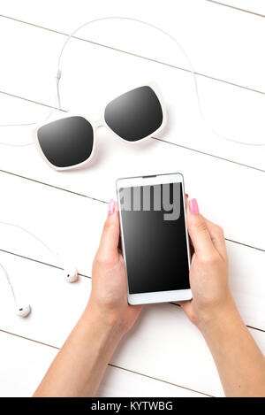 Woman using modern smart phone over white wooden table Stock Photo