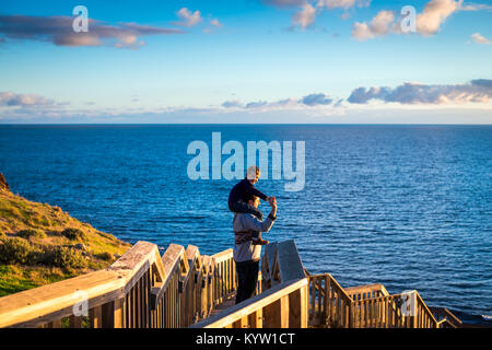 Father giving his son piggyback ride at sunset in South Australia Stock Photo
