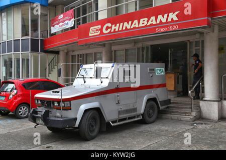 MANILA, PHILIPPINES - DECEMBER 8, 2017: Armored truck team handles money at Chinabank in Manila, Philippines. Chinabank groupa has 450 branches in Phi Stock Photo