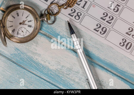 Antique Silver Pocket Watch,Pen and Calendar on Wooden Background Stock Photo
