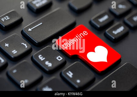 Word Valentine written on a computer keyboard and a heart Stock Photo