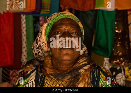 A headshot portrait of an aged woman in Gambia wearing a headpiece. Stock Photo