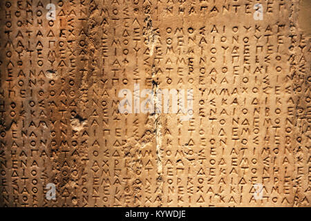 Ancient Greek carved into stone with cracked and chipped areas - background Stock Photo