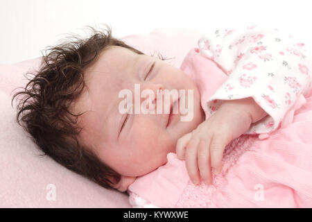 3 week old baby girl with lots of dark hair laying on rug Stock Photo