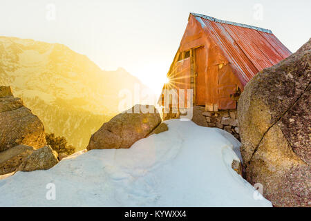 Secluded & beautiful Cabin in the snow mountains at Triund hill top, Mcleod ganj, Dharamsala, India during amazing sunrise from behind the mountains Stock Photo