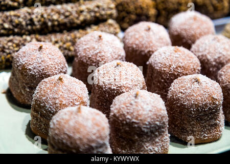 Chocolate-coated marshmallow treats with coconut sprinkles (skumboll) in a shop display, Stockholm, Sweden Stock Photo