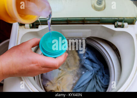 Woman hand pouring washing powder into the washing machine washing powder into the washing machine Stock Photo