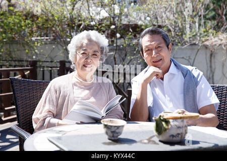 The old couple in the courtyard to read Stock Photo