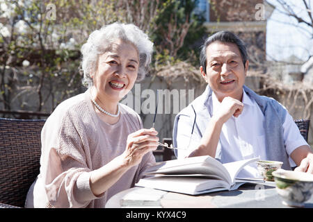 The old couple read in the courtyard Stock Photo