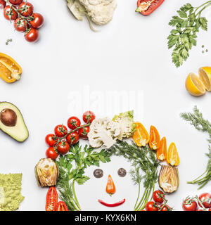 Healthy lifestyle concept. Various fresh vegetables with funny face made with ingredients on white background, top view, frame. Layout for Detox, diet Stock Photo