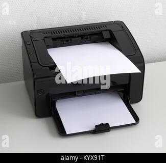 Compact laser home printer on a white desk Stock Photo
