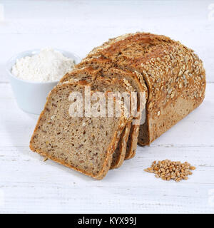 Whole wheat grain bread slice slices sliced loaf square on wooden board wood Stock Photo