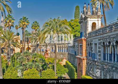 ALCAZAR OF SEVILLE SPAIN VIEW FROM COVERED WALKWAY THE GALERIA DE GRUTESCOS TO THE FORMAL GARDENS WITH ORANGE TREES AND PALM TREES Stock Photo