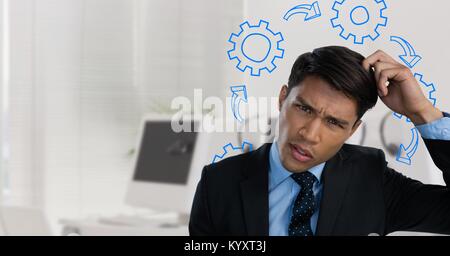 Confused man scratching his head and frowning surrounded by cogs Stock Photo