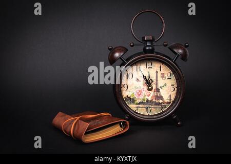 Close up of an old vintage watch with vintage planner on a black background Stock Photo