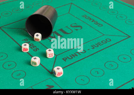 Five poker dices of ases and beaker on the green casino field Stock Photo