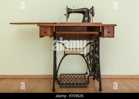 Bacau,Romania - May 16, 2011: Image of the old Singer Sewing machine in a empty room with parquet. Issac Singer built the first sewing machine with ve Stock Photo