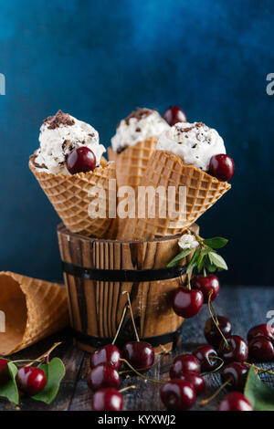 Close-up of ice cream with cherries on table against colored background