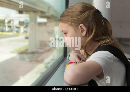 Side view of thoughtful girl looking through window Stock Photo