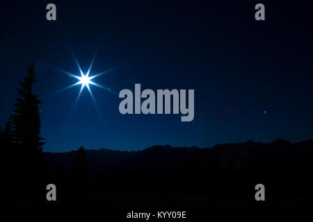 Majestic view of moon shining over silhouette landscape against star field Stock Photo