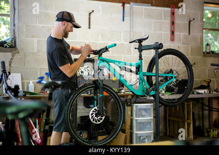 Mechanic repairing mountain bike in bicycle shop Stock Photo