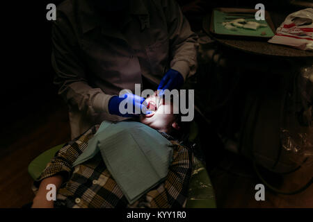 High angle view of dentist examining patient in darkroom Stock Photo