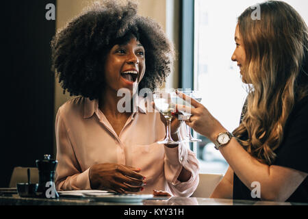 Cheerful businesswomen toasting drinks in hotel Stock Photo