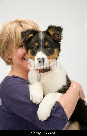 Lady dog owner happily cuddles her new puppy Stock Photo