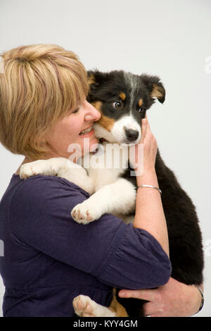 Lady dog owner happily cuddles her new puppy Stock Photo