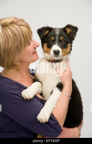 Lady dog owner happily cuddles her new puppy Stock Photo