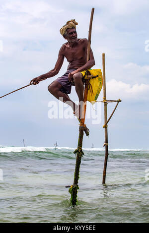WELIGAMA, SRI LANKA - CIRCA DECEMBER 2013: Stilt fisherman Stock Photo
