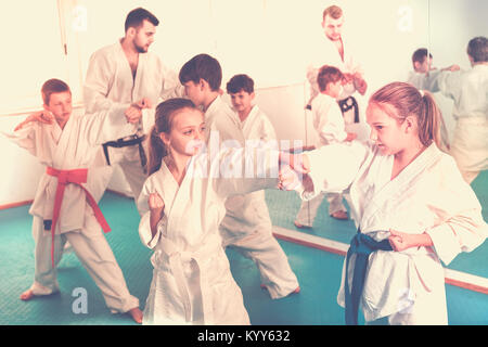 Young  teenagers practicing new karate moves in pairs in class Stock Photo