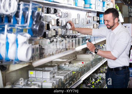 Happy man selecting electric socket in household department Stock Photo