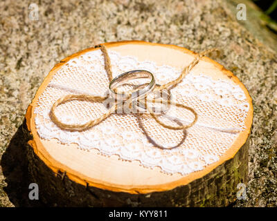 wedding rings lie on a natural wood sawing Stock Photo