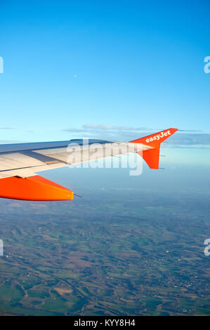 An Easyjet aircraft wing in flight seen from the cabin. Stock Photo