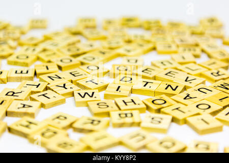 Scattered wooden scrabble letters on a white background Stock Photo