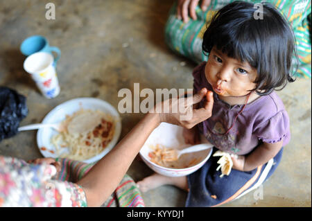 A maya indigenous girl is fed meal provided by local NPO in Aqua Escondida, Solola, Guatemala. Stock Photo