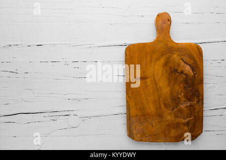 Vintage cutting board with copy space on white wooden background, view from above Stock Photo
