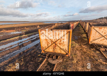 Peat mining area with old empty carts in the foreground Stock Photo